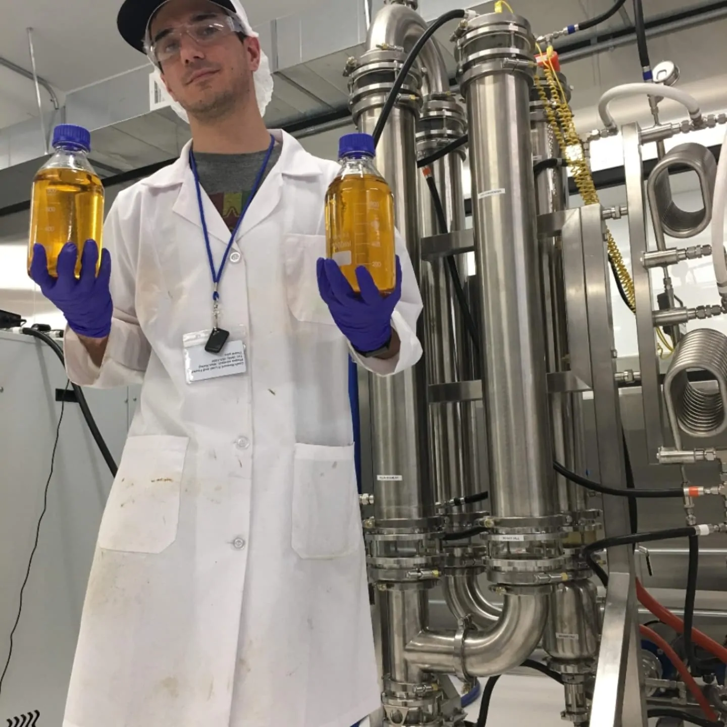 Brian Denovio holding cannabis extract bottles in the lab